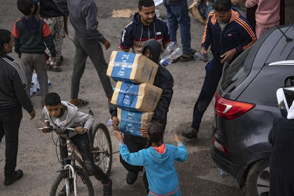 Palestinians loot a humanitarian aid truck as it crossed into the Gaza Strip in Rafah, Sunday, Dec. 17, 2023. (AP Photo/Fatima Shbair)