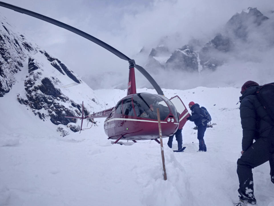 In this Saturday, Jan. 18, 2020 photo, trekkers are being rescued in an helicopter a day after after an avalanche hit Mount Annapurna trail in Nepal. Special army and government rescue personnel were searching again on Monday for four South Korean trekkers and their three Nepali guides lost since an avalanche swept a popular trekking route in Nepal's mountains. (AP Photo/Phurba Ongel Sherpa)