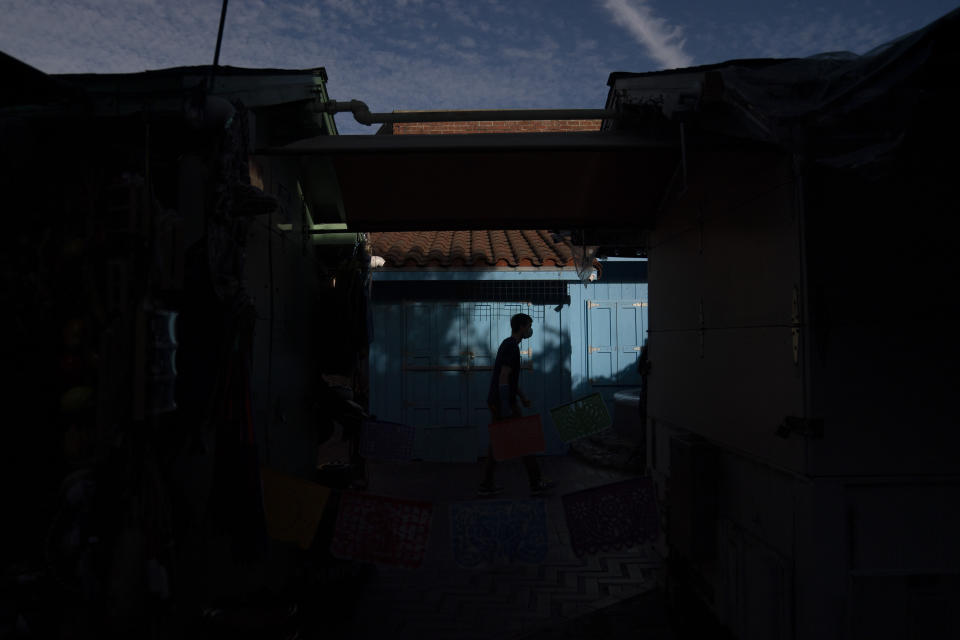 A man walks along Olvera Street Tuesday, June 8, 2021, in Los Angeles. Most businesses are no longer open daily and many have cut back to four or five days, said Valerie Hanley, treasurer of the Olvera Street Merchants Association Foundation and a shop owner. "We're not like a local restaurant in your town," Hanley said. "We're one of those little niche things. If you can't fill the niche with the right people, we're in trouble." (AP Photo/Jae C. Hong)