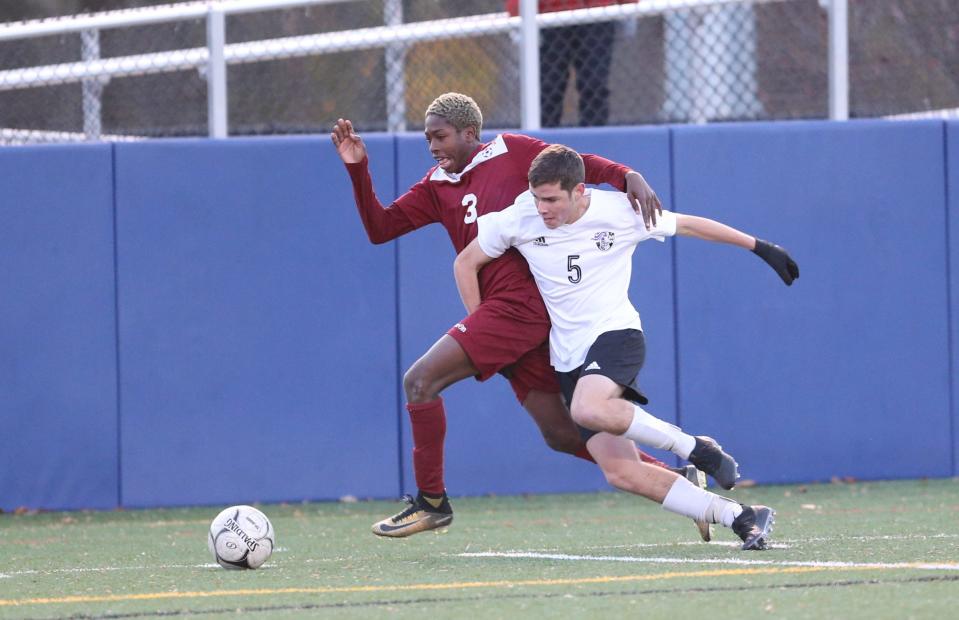 Ossining's Kevon Evans (3) works the ball against Monroe-Woodbury's Ethan Myers (5) during their 1-0 win in the NYSPHSAA Class AA boys soccer regional finals at Pace University in Pleasantville on Saturday, November 9, 2019.