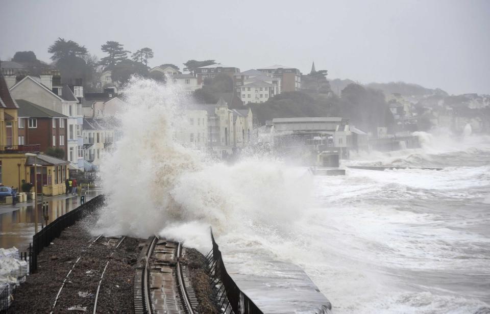 A huge wave breaks over the railway line, in Dawlish, England, Wednesday, Feb. 5, 2014. where high tides and strong winds have created havoc in the Devonshire town disrupting road and rail networks and damaging property. (AP Photo/PA, Ben Birchall) UNITED KINGDOM OUT