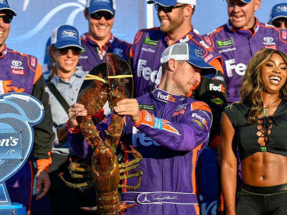 Denny Hamlin reacts as he holds a lobster winning at New Hampshire Motor Speedway in 2017.