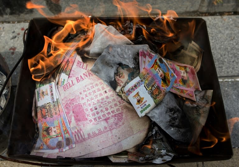 Chinese relatives burn so-called 'spirit money' as an offering during the annual "Qingming" festival in Shanghai