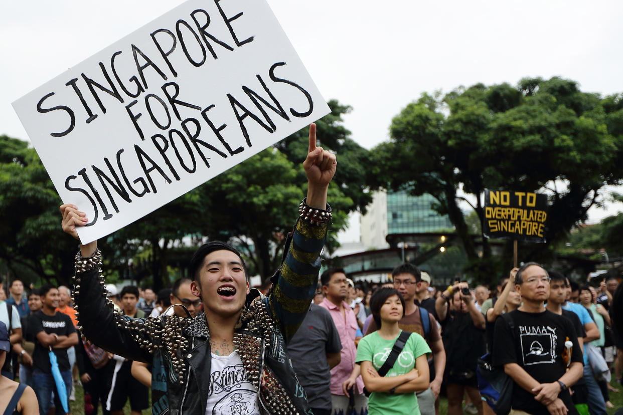 SINGAPORE - FEBRUARY 16:  A man reacts to a speaker during the protest against the government's White Paper on Population at Speakers' Corner speech at Hong Lim Park on February 16, 2013 in Singapore. Thousands of protesters gathered today following the release of a government white paper on population that revealed it could increase 30% to 6.9 million by 2030, angering residents who already see a strain on housing, transportation and healthcare.  (Photo by Suhaimi Abdullah/Getty Images)