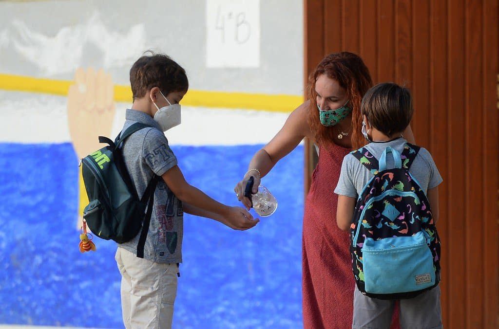 Une enseignante en train de désinfecter les mains d'un élève dans une école près de Séville. - Cristina Quicler