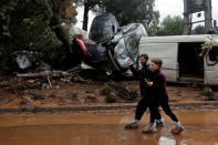 <p>Locals wear plastic bags to protect from mud as they walk next to destroyed cars, following flash floods which hit areas west of Athens on November 15 killing at least 15 people, in Mandra, Greece, Nov. 16, 2017. (Photo: Alkis Konstantinidis/Reuters) </p>