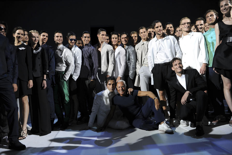 Fashion designer Giorgio Armani, sitting on the ground at center, poses with his models at the end of the men's Spring-Summer 2014 collection part of the Milan Fashion Week, unveiled in Milan, Italy, Monday, June 24, 2013. (AP Photo/Giuseppe Aresu)