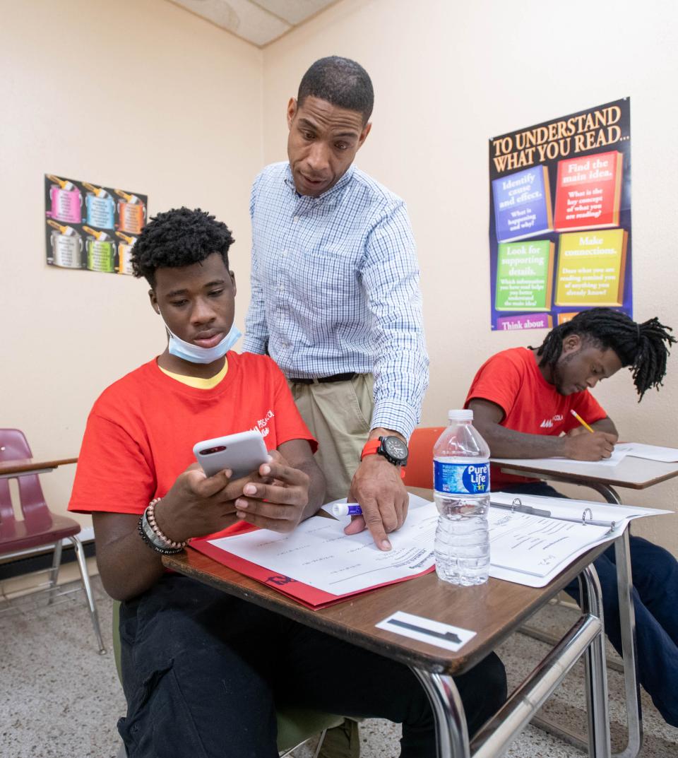 New executive director Pierre Cotton, center, assists J'lyn Saulsberry, 16, with an assignment during a GED math class at AMIkids in Pensacola on Tuesday, Feb. 14, 2023.
