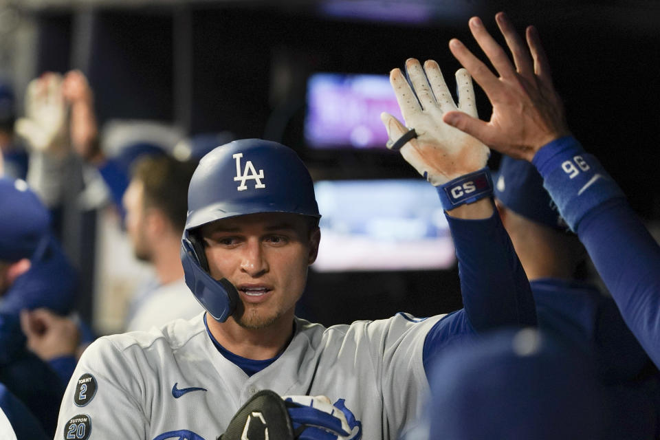Los Angeles Dodgers' Corey Seager is congratulated in the dugout after hitting a two-run home run against the Atlanta Braves during the first inning in Game 2 of baseball's National League Championship Series Sunday, Oct. 17, 2021, in Atlanta. (AP Photo/Brynn Anderson)