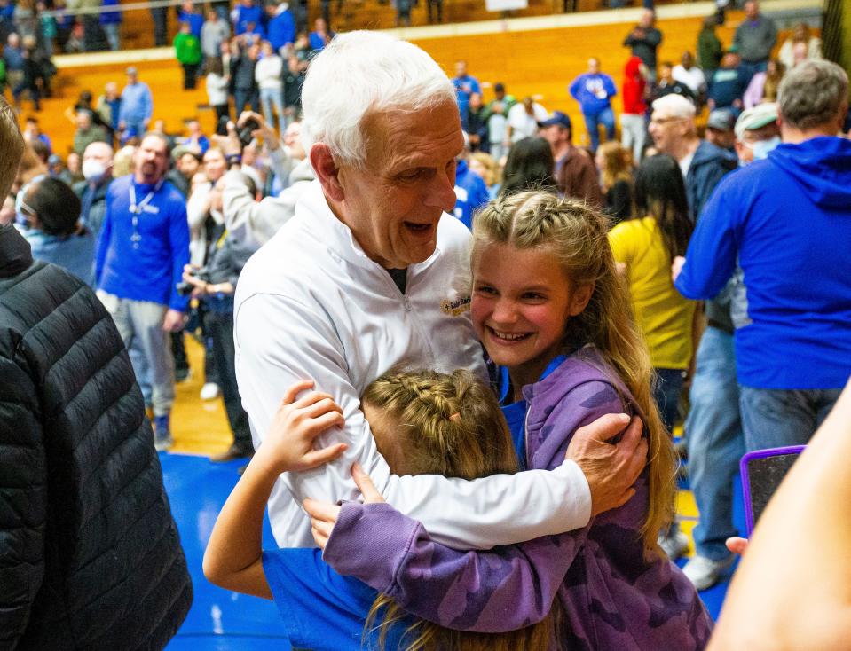 Bob Berger hugs family members after Marian defeated Leo to win the semistate championship in Elkhart.