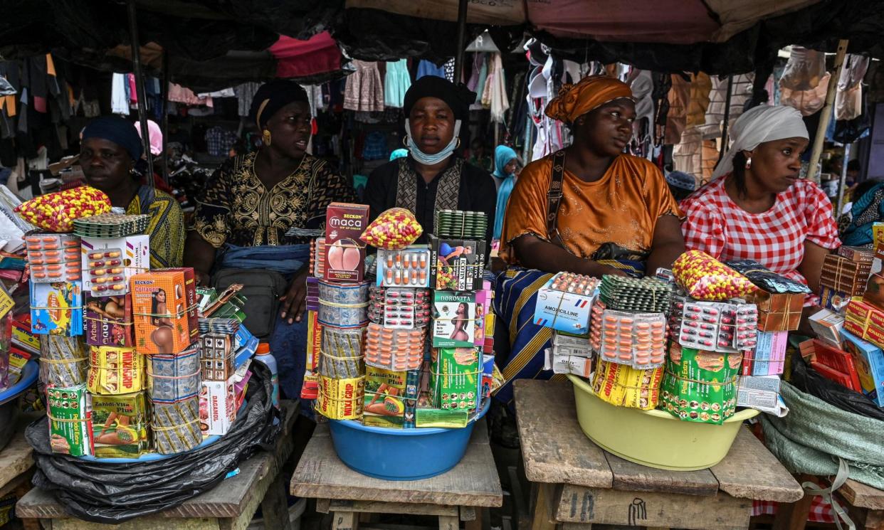 <span>Street vendors endure the heat at a market in Abobo, a suburb of Abidjan, Ivory Coast.</span><span>Photograph: Issouf Sanogo/AFP/Getty Images</span>