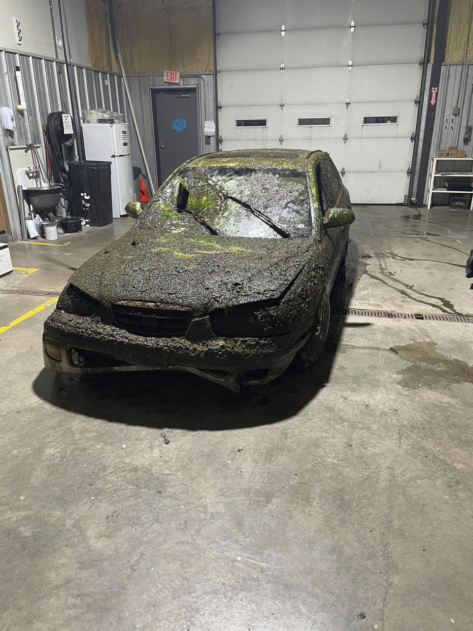 In a photo provided by the Camden County Sheriff's Office, a car is covered with moss, mold and plant matter inside a storage facility in Camdenton, Mo., on Dec. 17, 2023. Camden County deputies are once again investigating the disappearance of Donnie Erwin after dredging up his algae-encrusted vehicle in a tiny roadside drainage pond in December - almost exactly a decade after the 59-year-old went missing. (Detective Sgt Jeremiah Burnett/Camden County Sheriff’s Office via AP)