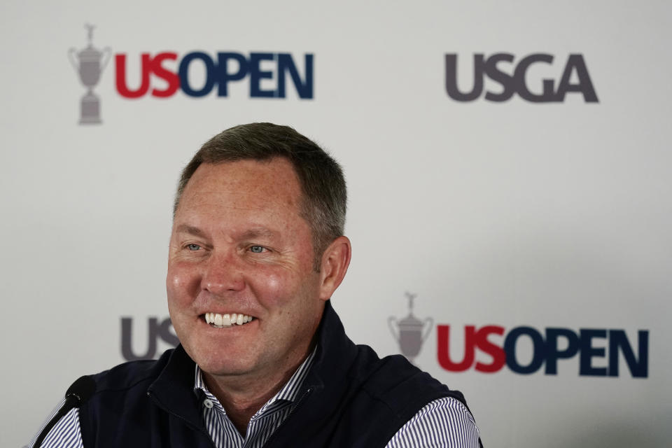 USGA's Mike Whan smiles during a news conference before the U.S. Open golf tournament at The Country Club, Wednesday, June 15, 2022, in Brookline, Mass. (AP Photo/Charlie Riedel)