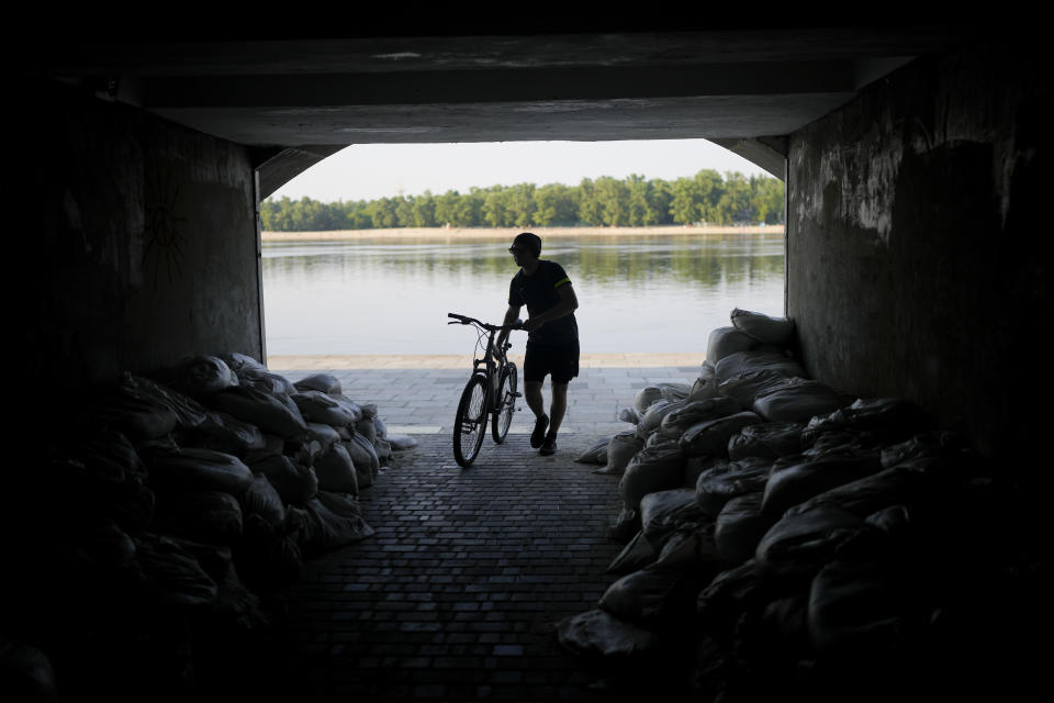 A man enters an underpass in Kyiv, Ukraine, Friday, June 10, 2022. With war raging on fronts to the east and south, the summer of 2022 is proving bitter for the Ukrainian capital, Kyiv. The sun shines but sadness and grim determination reign. (AP Photo/Natacha Pisarenko)