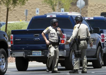 Metro Police officers confer outside a Wal-mart after a shooting in Las Vegas June 8, 2014. REUTERS/Las Vegas Sun/Steve Marcus