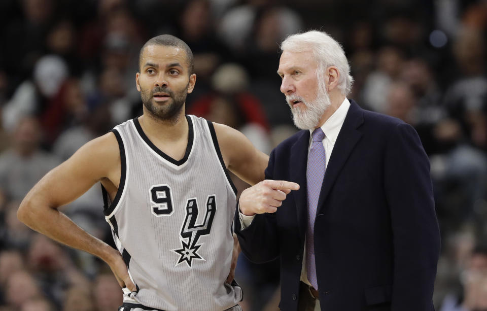 ARCHIVO - En esta foto del 30 de diciembre de 2016, el jugador de los Spurs, Tony Parker, izquierda, conversa con el entrenador Gregg Popovich durante un partido en San Antonio. (AP Foto/Eric Gay, Archivo)