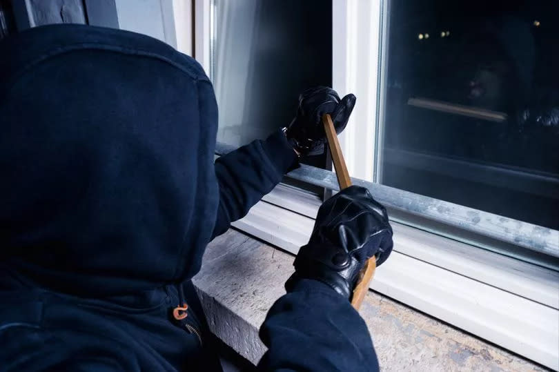 A burglar trying to force his way into a home -Credit:Getty Images