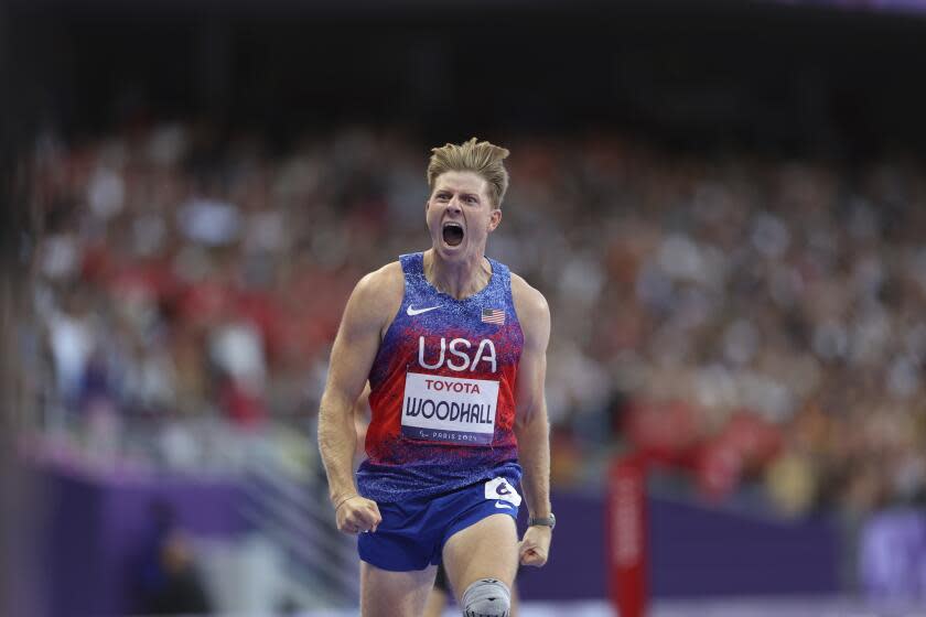 American Hunter Woodhall shouts and celebrates after winning the men's 400-meter T62 final at the Paralympics Friday