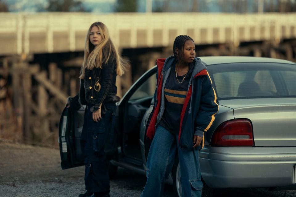 two women standing next to a car