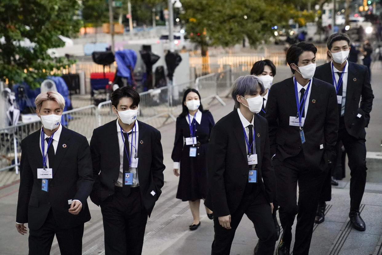 Members of the South Korean band BTS, from left, J-Hope, Jung Kook, Suga, Jimin, partially obscured, Jin and RM arrive to security check-in at United Nations headquarters, Monday, Sept. 20, 2021, during the 76th Session of the U.N. General Assembly in New York. BTS have raised $3.6 million and generated millions of tweets during four years of teaming up with the U.N. children's agency to fight violence, abuse and bullying and promote self-esteem in young people, the agency is announcing Wednesday, Oct. 6, 2021.  (AP Photo/John Minchillo, Pool)