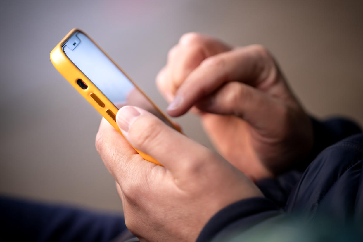 Smartphone in male hands. Close up of hands with a phone. Outdoor photo Cyber Monday