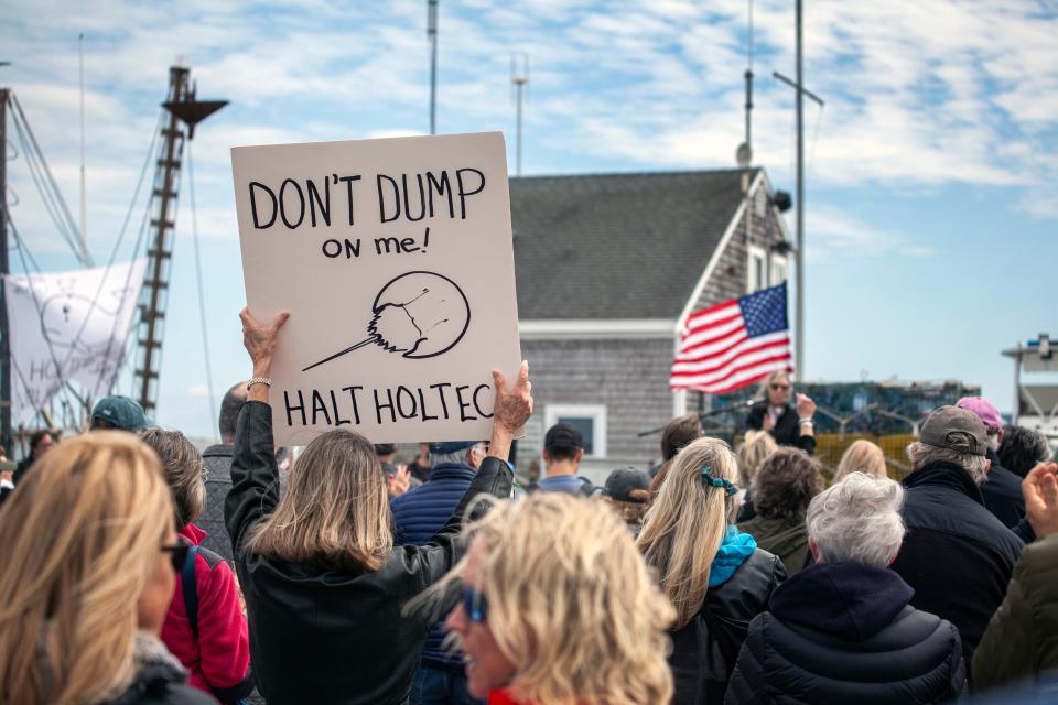 A protester holding a sign with a drawing of a horseshoe crab during the rally against Holtec releasing wastewater from the decommissioned Pilgrim Nuclear Power Station into Cape Cod Bay in Plymouth on Saturday, April 9, 2022.