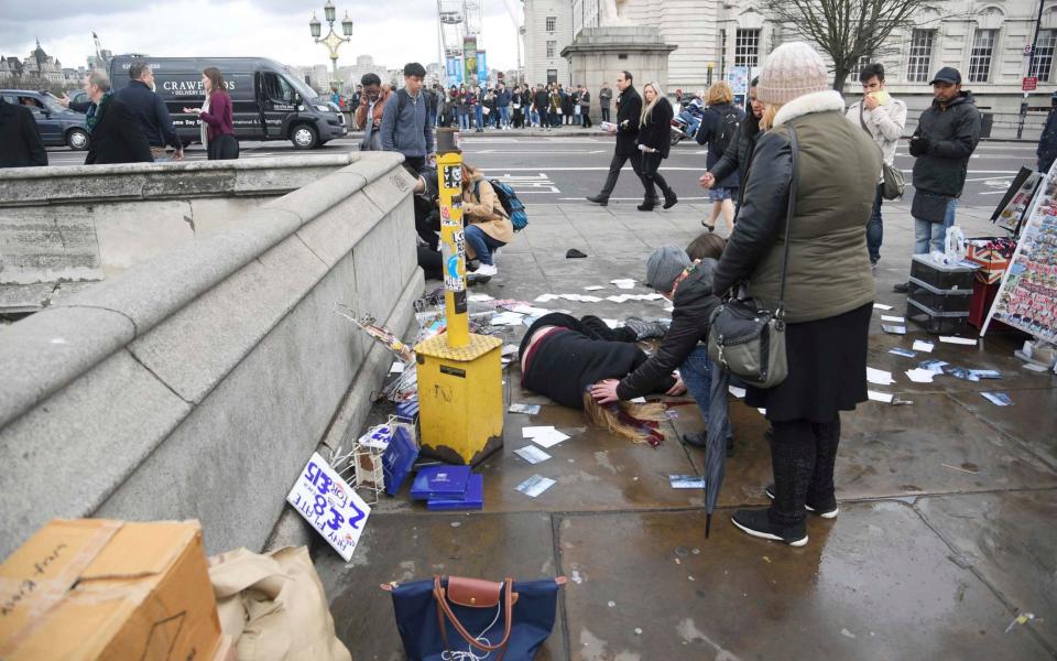 Injured people are assisted on Westminster Bridge - Credit: TOBY MELVILLE/Reuters