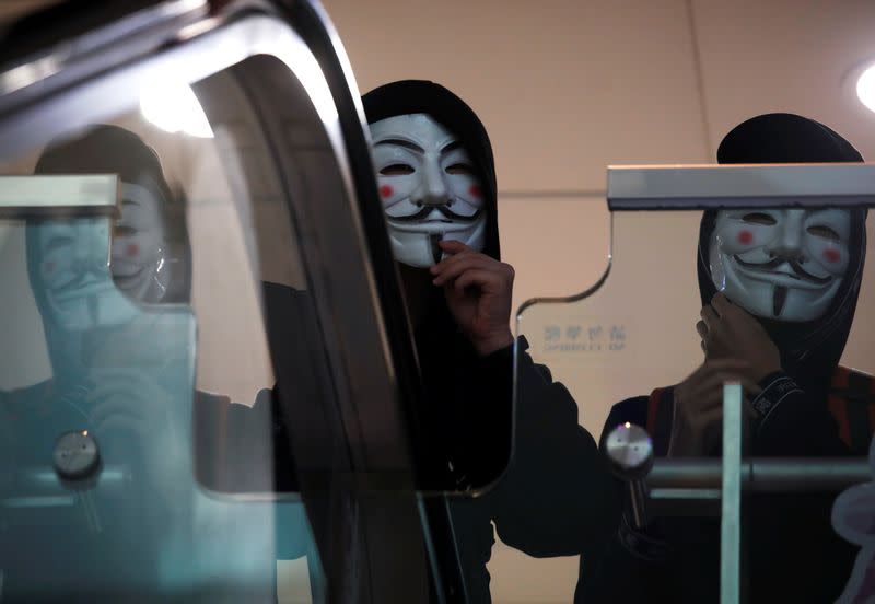 Anti government protesters wearing Guy Fawkes masks march inside the Sheung Shui shopping mall in Hong Kong