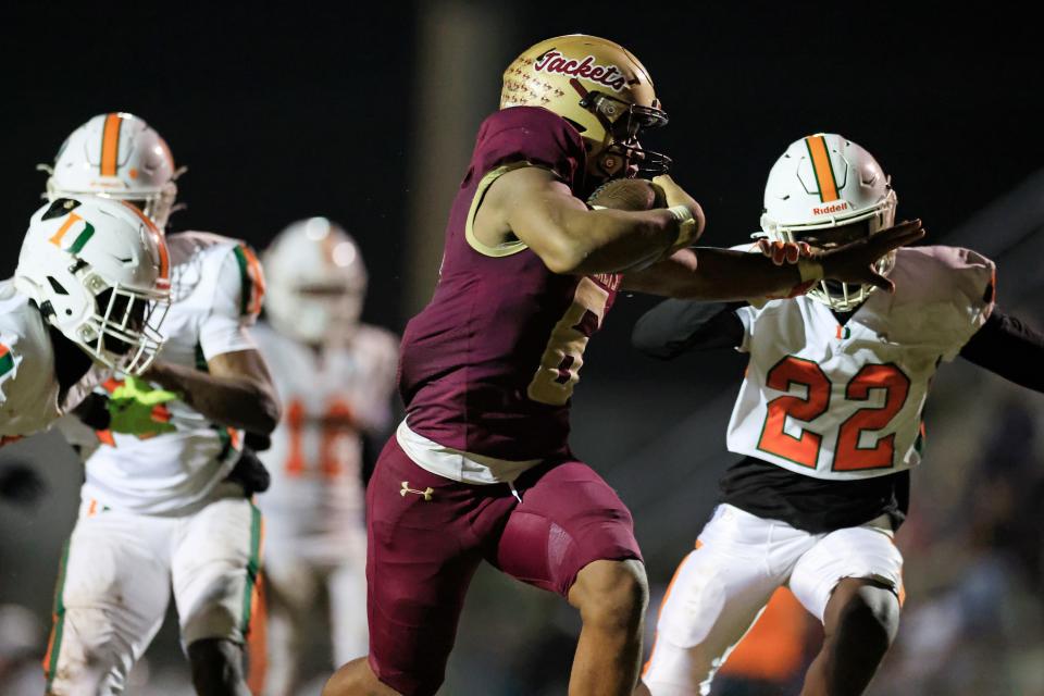 St. Augustine's Devonte Lyons (6) fends off Dunbar's Almirian Thomas (22) en route to a touchdown.