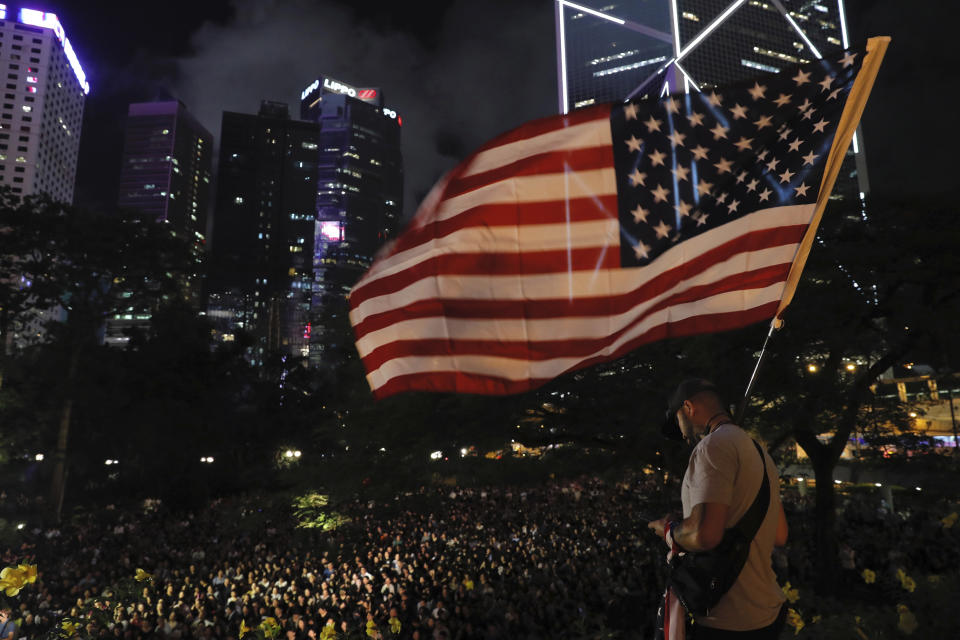 American Joey Gibson from Washington raises the American flag as he shows support at a rally by mothers for student protesters in Hong Kong on Friday, Jan. 5, 2019. The societal divide in Hong Kong showed no sign of closing Friday as students rebuffed an offer from city leader Carrie Lam to meet and a few thousand mothers rallied in support of the young protesters who left a trail of destruction in the legislature's building at the start of the week. (AP Photo/Kin Cheung)