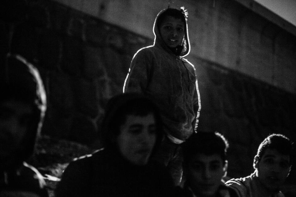 A group of Moroccan kids sit on the breakwater at Melilla’s harbor in 2014. (Photo: José Colón/MeMo for Yahoo News)