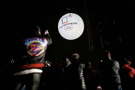 FILE PHOTO - Photographers take photographs of a giant inflatable ball bearing the logo of the 2018 Pyeongchang Winter Olympics in Incheon, South Korea, November 1, 2017. REUTERS/Kim Hong-Ji