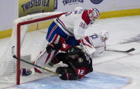 Ottawa Senators right wing Alex DeBrincat (12) slides into Montreal Canadiens goaltender Sam Montembeault (35) after being brought down by Canadiens defenseman Mike Matheson (8) during first-period NHL hockey game action Saturday, Jan. 28, 2023, in Ottawa, Ontario. (Adrian Wyld/The Canadian Press via AP)