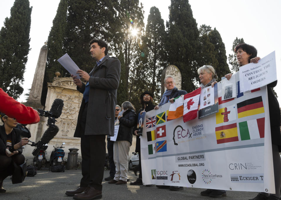 Child psychologist and founding member of the Ending Clergy Abuse (ECA) organization, Miguel Hurtado from Spain, center, reads an open letter to the Benedictine order outside the St. Anselm on the Aventine Benedictine complex in Rome on the second day of a summit called by Pope Francis at the Vatican on sex abuse in the Catholic Church, Friday, Feb. 22, 2019. Pope Francis has issued 21 proposals to stem the clergy sex abuse around the world, calling for specific protocols to handle accusations against bishops and for lay experts to be involved in abuse investigations. (AP Photo/Domenico Stinellis)