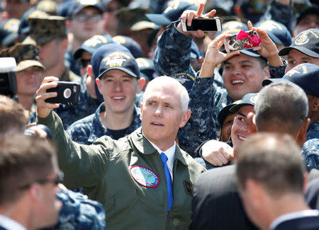 U.S. Vice President Mike Pence takes selfie photo with U.S service members as he visits the USS Ronald Reagan, a Nimitz-class nuclear-powered super carrier, at the U.S. naval base in Yokosuka, south of Tokyo, Japan April 19, 2017. REUTERS/Kim Kyung-Hoon