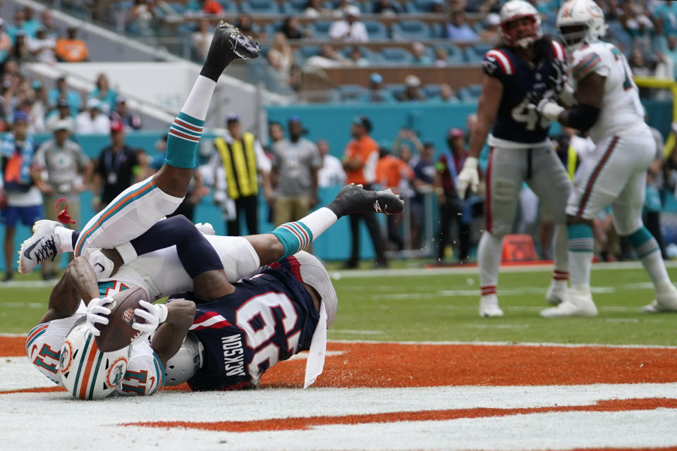 Miami Dolphins wide receiver Cedrick Wilson Jr. (11) scores a touchdown under pressure from New England Patriots cornerback J.C. Jackson (29) during the first half of an NFL football game, Sunday, Oct. 29, 2023, in Miami Gardens, Fla. (AP Photo/Lynne Sladky)