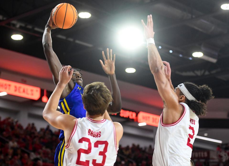 South Dakota State’s William Kyle III reaches up to dunk over the heads of South Dakota’s Paul Bruns and Damani Hayes in a rivalry matchup on Saturday, January 14, 2023, at the Sanford Coyote Sports Center in Vermillion.