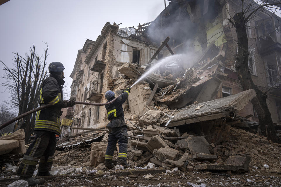 Ukrainian State Emergency Service firefighters work to extinguish a fire at the building which was destroyed by a Russian attack in Kryvyi Rih, Ukraine, Friday, Dec. 16, 2022. Russian forces launched at least 60 missiles across Ukraine on Friday, officials said, reporting explosions in at least four cities, including Kyiv. At least two people were killed by a strike on a residential building in central Ukraine, where a hunt was on for survivors. (AP Photo/Evgeniy Maloletka)