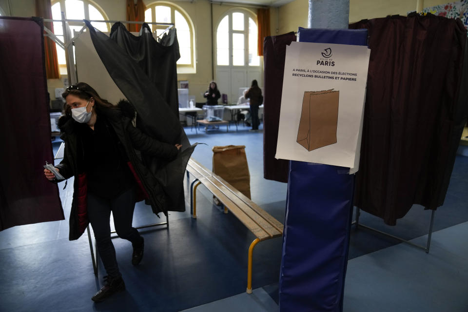 A woman votes at a polling station in Paris, France, Sunday, April 24, 2022. France began voting in a presidential runoff election Sunday with repercussions for Europe's future, with centrist incumbent Emmanuel Macron the front-runner but fighting a tough challenge from far-right contender Marine Le Pen. (AP Photo/Francois Mori)