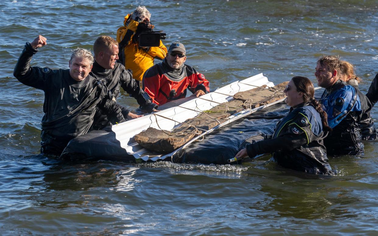 James Skibo raises his fist in the air as he celebrates successfully recovering a 3,000-year-old dugout canoe from Lake Mendota in Madison, Wis. on Thursday, Sept. 22, 2022. Skibo, the state archaeologist, died last week in a diving accident. He had learned to dive to better understand the work his staff was doing.
