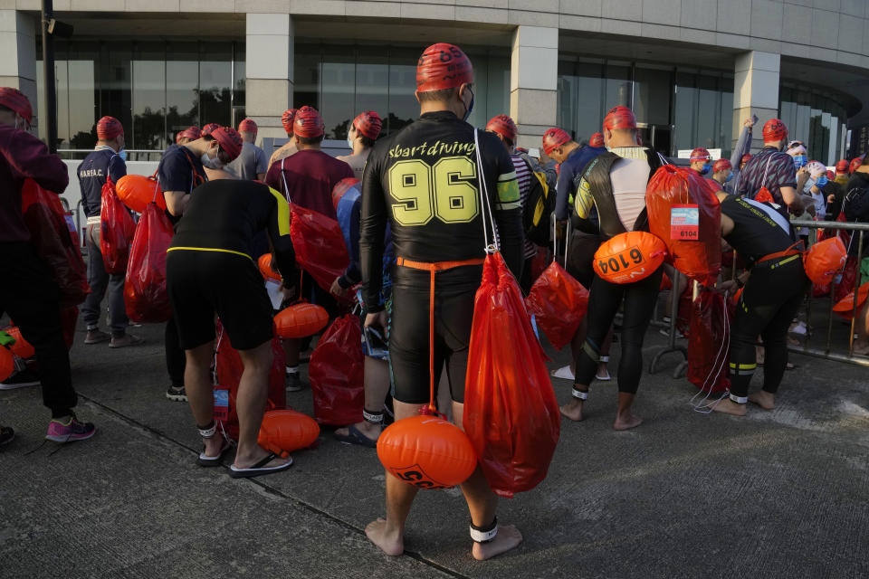 Competitors prepare for a harbor race at the Victoria Harbor in Hong Kong, Sunday, Dec. 12, 2021. Hundreds of people took part in traditional swim across iconic Victoria Harbor after two years of suspension. (AP Photo/Kin Cheung)