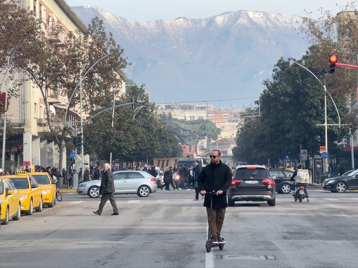 Opening up: Tirana street scene, dominated by snow-capped mountains (Simon Calder)