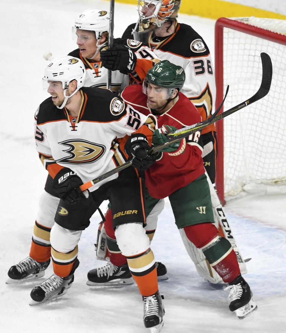 Minnesota Wild's Jason Zucker, right, gets sandwiched between Anaheim Ducks' Shea Theodore, left and Cam Fowler, center, in front of Ducks' goalie John Gibson (35) in the second period of an NHL hockey game, Tuesday, Feb. 14, 2017, in St. Paul, Minn.(AP Photo/Tom Olmscheid)