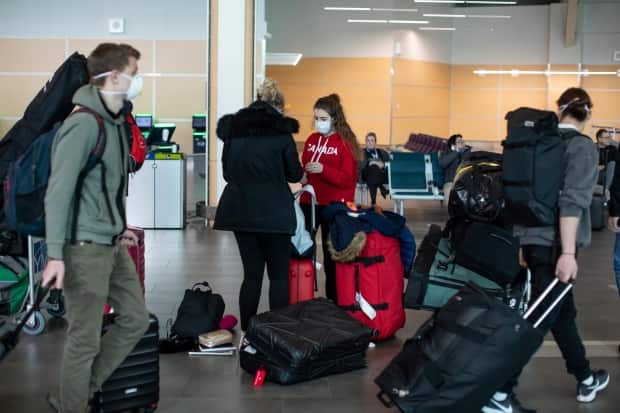 Passengers are shown at the Vancouver International Airport in March 2020. Travellers will not be able to book accommodations outside of their local health authority for the next five weeks until May 24, the end of the long weekend.