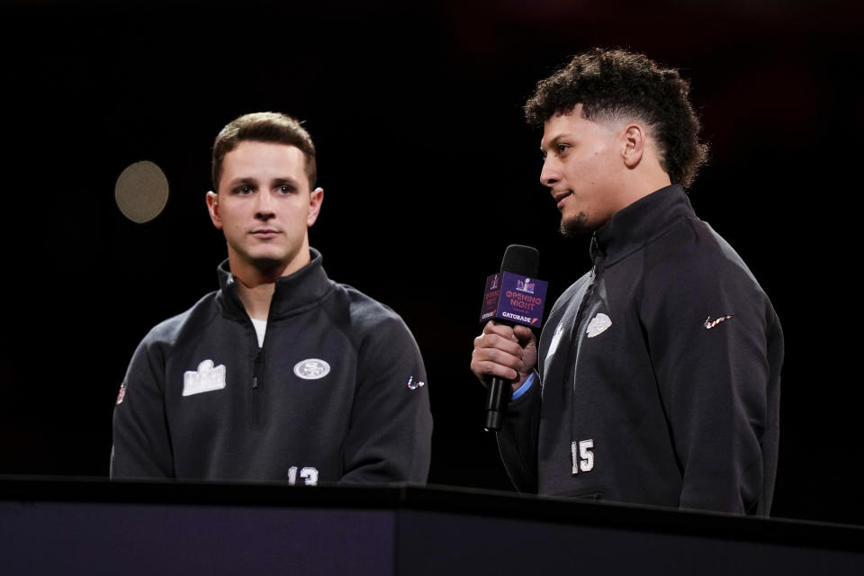 Kansas City Chiefs quarterback Patrick Mahomes speaks to the media as San Francisco 49ers quarterback Brock Purdy looks on during NFL football Super Bowl 58 opening night Monday, Feb. 5, 2024, in Las Vegas. The San Francisco 49ers face the Kansas City Chiefs in Super Bowl 58 on Sunday. (AP Photo/Charlie Riedel)