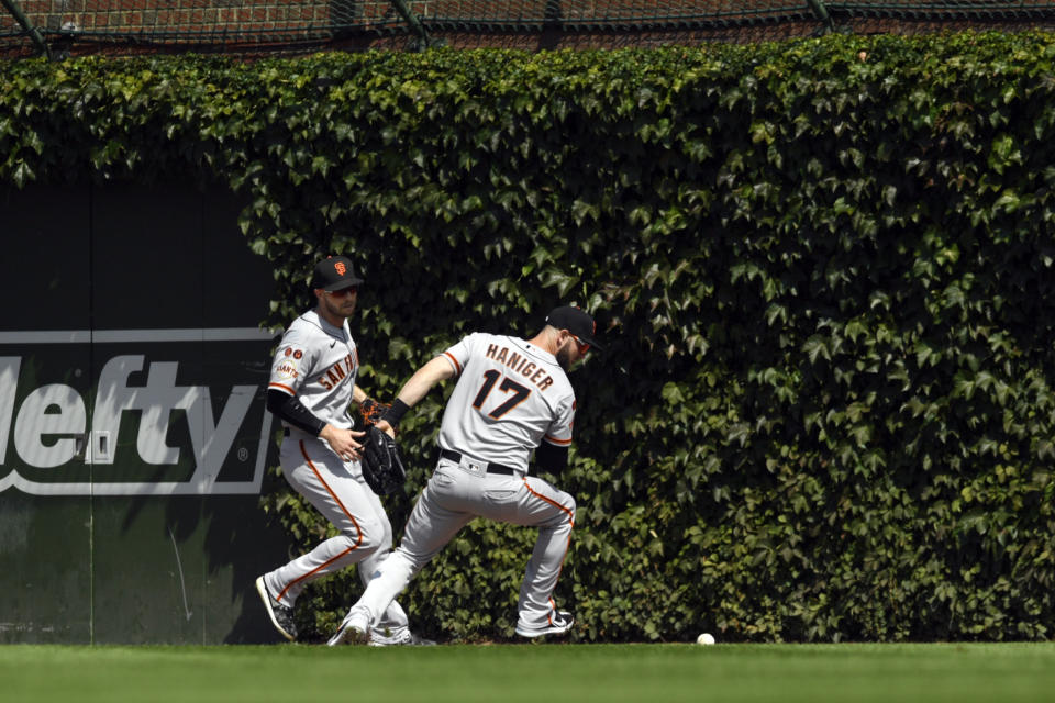 San Francisco Giants right fielder Mitch Haniger (17) chases down a 3-run double hit by Chicago Cubs' Seika Suzuki during the first inning of a baseball game as teammate center fielder Austin Slater left, looks on Wednesday, Sept. 6, 2023, in Chicago. (AP Photo/Paul Beaty)