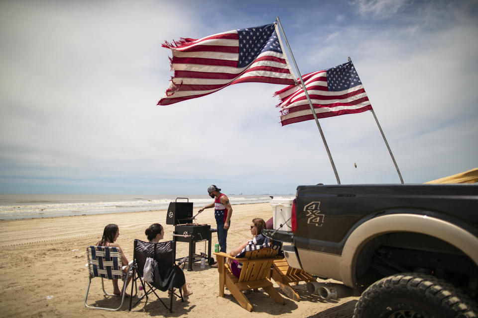 File - The Stratton family, from Cypress, enjoys the day barbecuing and playing games after weeks of isolation due to the coronavirus pandemic, during the Jeep Weekend gathering at Crystal Beach on the Bolivar Peninsula, Texas, Sunday, May 17, 2020. (Marie D. De Jesús/Houston Chronicle via AP, File)