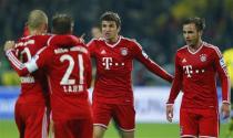 Bayern Munich's Thomas Mueller (C) celebrates next to Mario Goetze (R) after Mueller scored a goal against Borussia Dortmund during their German first division Bundesliga soccer match in Dortmund, November 23, 2013. REUTERS/Kai Pfaffenbach