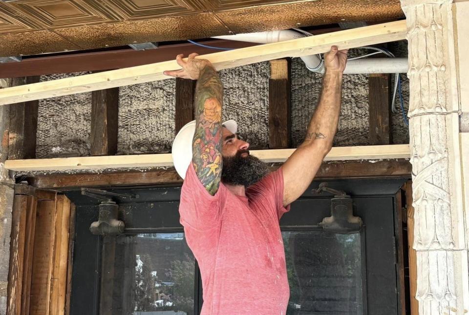 Blake Wright of Petersburg works on wood fascia at Hotel Petersburg outdoors during a heat wave in July 2024.