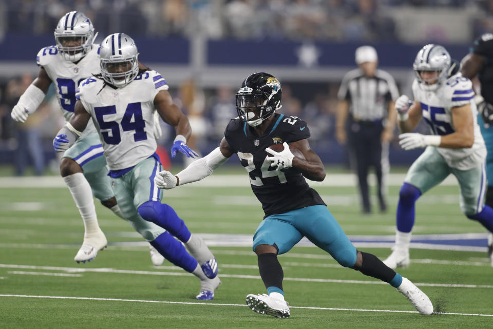 Jacksonville Jaguars running back T.J. Yeldon (24) carries past Dallas Cowboys linebacker Jaylon Smith (54) in the second half of an NFL football game in Arlington, Texas, Sunday, Oct. 14, 2018. (AP Photo/Jim Cowsert)